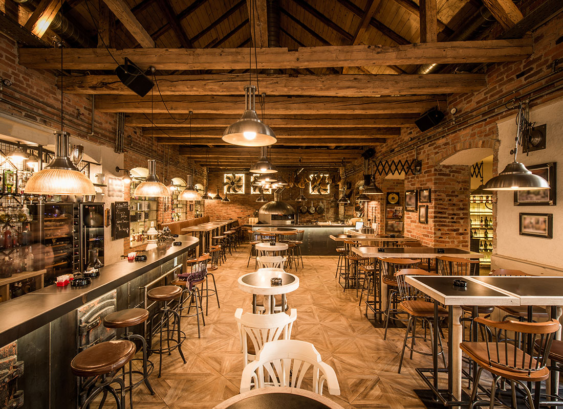 Insurance by Industry - Interior View of a Rustic Cafe with Wooden Beams on the Ceiling and Red Brick Walls